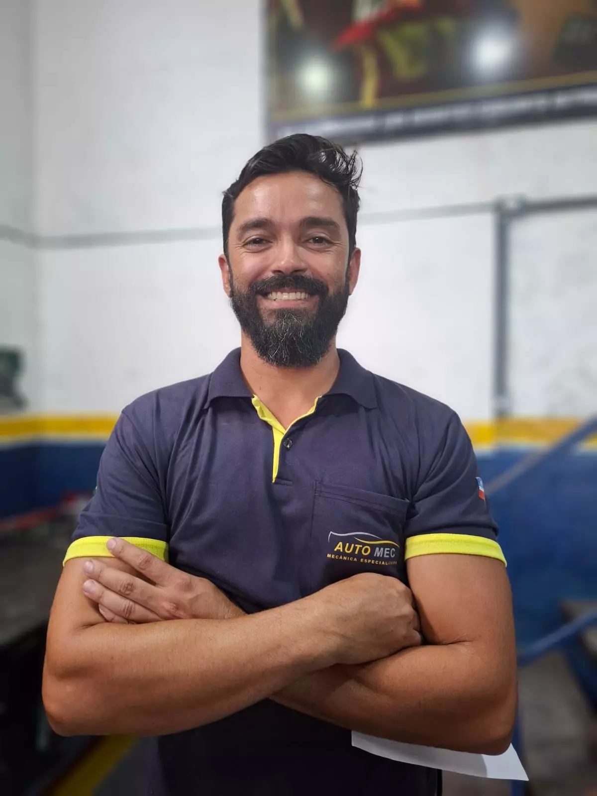 Mecânico da equipe Automec sorrindo dentro da oficina em Guaratinguetá